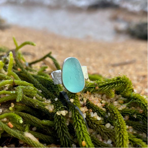 Blue sea glass set in silver on a cast beach feather inspired silver ring band by Mornington Sea Glass. Size 7 3/4.