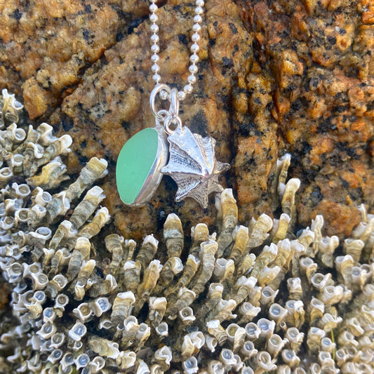 Sterling silver necklace of a cast silver shell with green sea glass charm. Hangs on a 40 or 45cm sterling silver chain.By Mornington Peninsula.