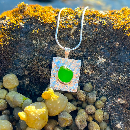 Green sea glass set on a mermaid scale textured backing pendant by Mornington Sea Glass. Comes with a 40 or 45cm sterling silver chain.