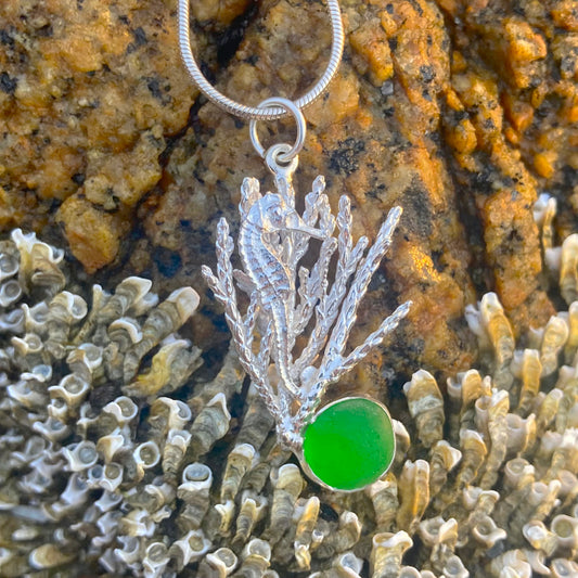 Sterling silver necklace of a cast seahorse hiding in coral with a green sea glass treasure. Hangs  on a 40 or 45cm sterling silver chain. By Mornington Sea Glass.