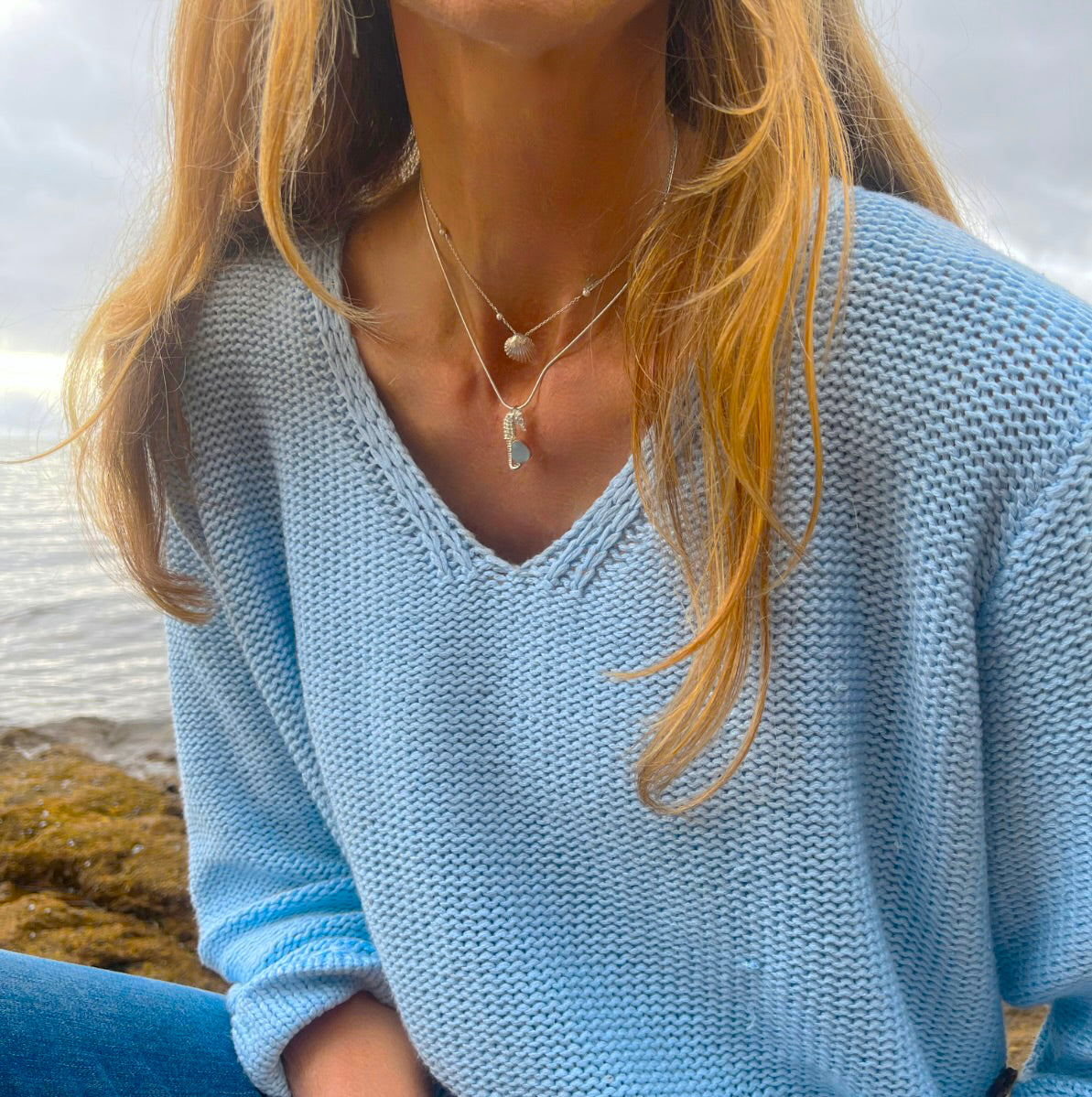 Sterling silver necklace of a small cast silver seahorse with a tiny blue sea glass treasure. Hangs on a 40 or 45cm sterling silver chain. By Mornington Sea Glass.