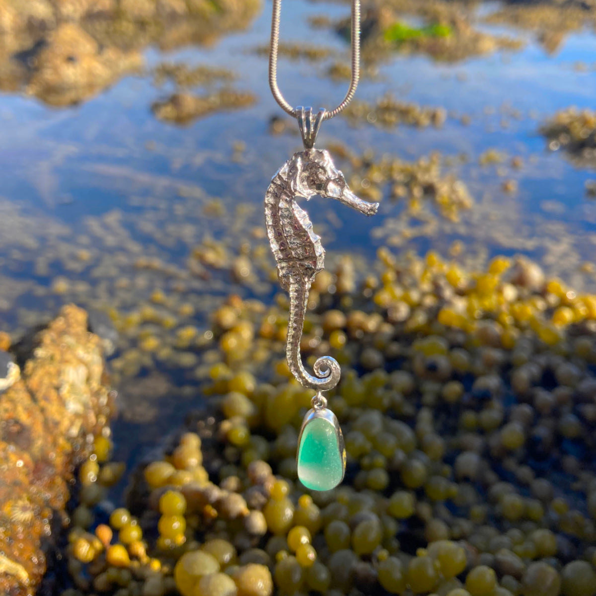 Cast silver seahorse and multi colour green, yellow and white sea glass pendant by Mornington Sea Glass photographed at rock pools on the Mornington Peninsula, Victoria, Australia
