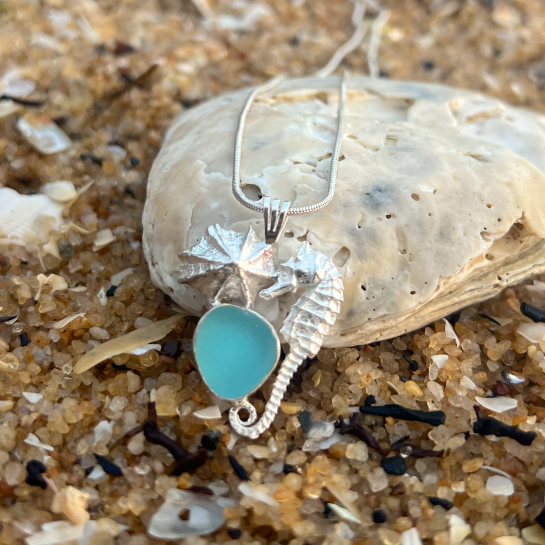 Sterling silver necklace of a small cast silver seahorse, limpet shell and blue sea glass treasure. Hangs on a 40 or 45cm sterling silver chain. By Mornington Sea Glass.