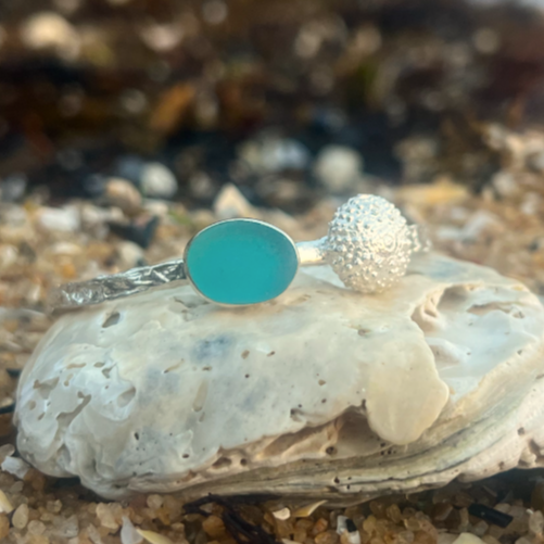 Sterling silver crushed texture cuff featuring a cast silver sea urchin shell and an ocean teal sea glass gem. 60cm diameter with a 3cm opening.By Mornington Sea Glass