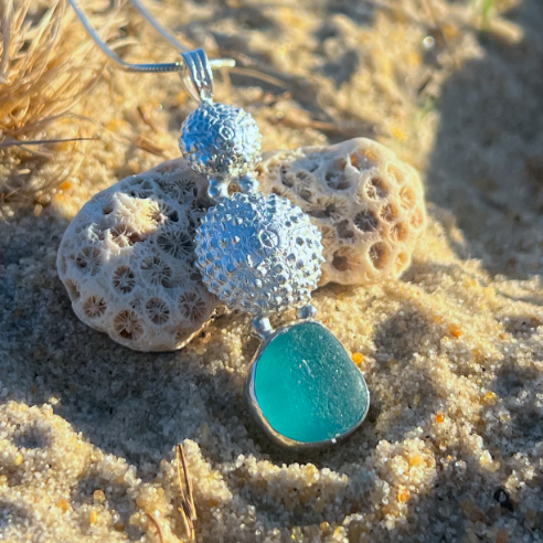 Sterling silver necklace of cast silver sea urchin shells and blue sea glass. Hangs on a 40 or 45cm sterling silver chain. By Mornington Sea Glass.
