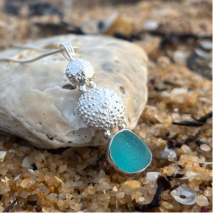 Sterling silver necklace of cast silver sea urchin shells and blue sea glass. Hangs on a 40 or 45cm sterling silver chain. By Mornington Sea Glass.