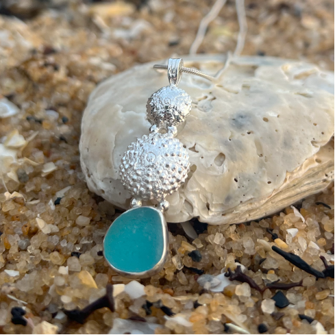 Sterling silver necklace of cast silver sea urchin shells and blue sea glass. Hangs on a 40 or 45cm sterling silver chain. By Mornington Sea Glass.