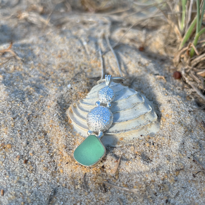 Sterling silver necklace of cast silver sea urchin shells and green sea glass. Hangs on a 40 or 45cm sterling silver chain. By Mornington Sea Glass.
