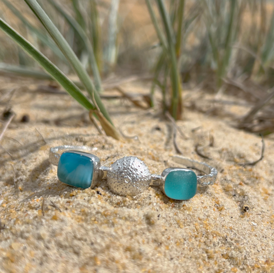 Sterling silver crushed texture cuff featuring a cast silver sea urchin shell, an ocean teal sea glass gem and natural Larimar.. 60cm diameter with a 3cm opening.By Mornington Sea Glass