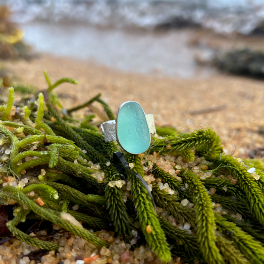 Blue sea glass set in silver on a cast beach feather inspired silver ring band by Mornington Sea Glass. Size 7 3/4.