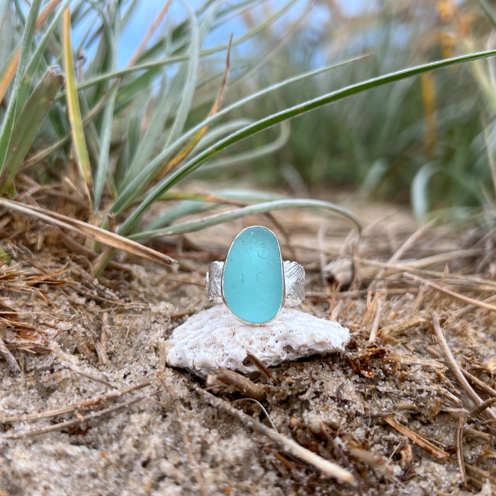 Blue sea glass set in silver on a cast beach feather inspired silver ring band by Mornington Sea Glass. Size 7 3/4.