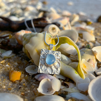 Cornflower blue sea glass set on a mermaid scale textured backing pendant by Mornington Sea Glass. Comes with a 40 or 45cm sterling silver chain.