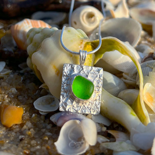 Green sea glass set on a mermaid scale textured backing pendant by Mornington Sea Glass. Comes with a 40 or 45cm sterling silver chain.