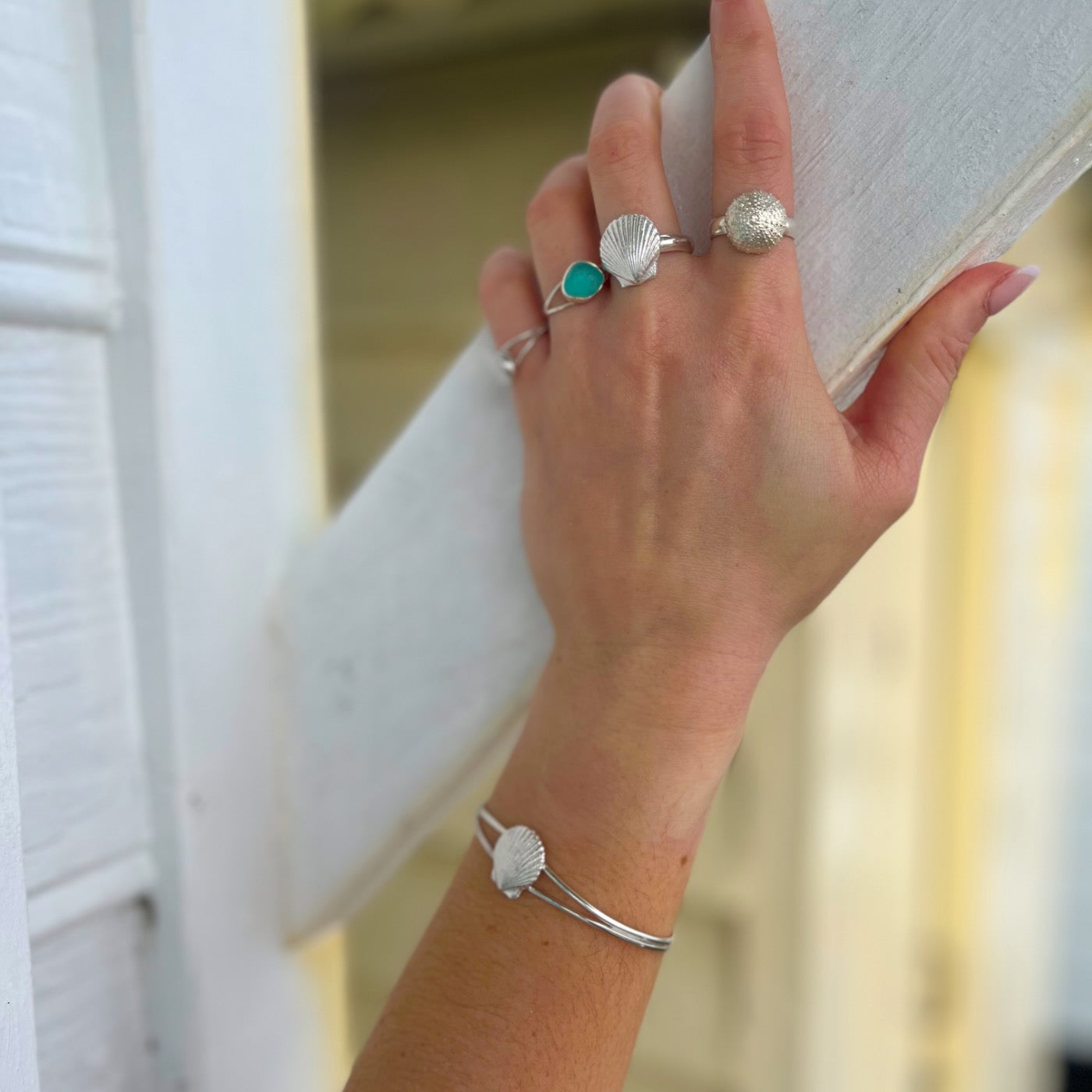 Hands modelling sea glass and cast silver shell rings and bangles by Mornington Sea Glass