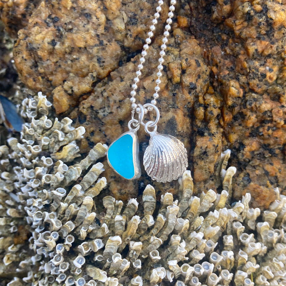Sterling silver necklace of a cast silver shell with blue  sea glass charm. Hangs on a 40 or 45cm sterling silver chain. By Mornington Sea Glass.