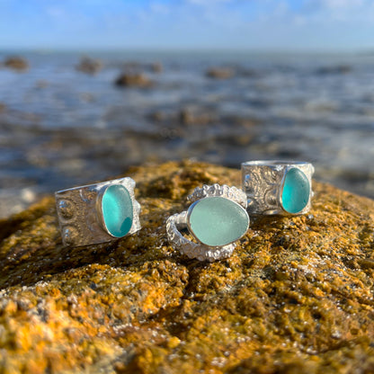 Collection of cast silver sea urchin and octopus tentacle ring bands with blue sea glass by Mornington Sea Glass. 