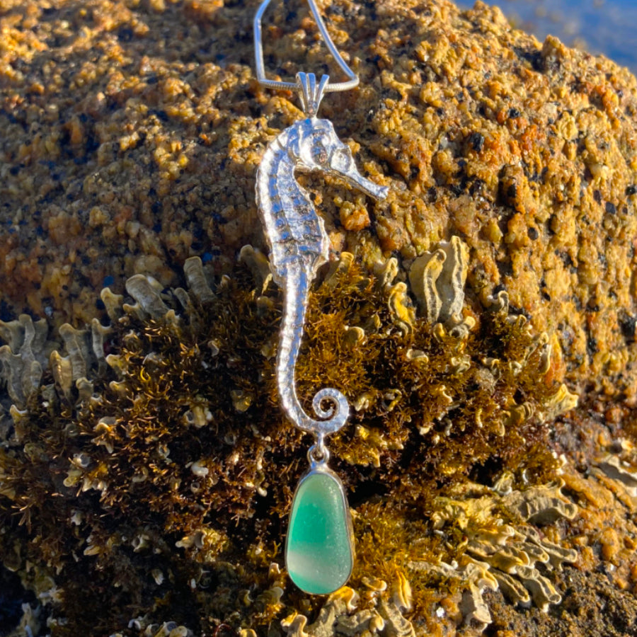 Sterling silver necklace of a cast silver seahorse with a rare English multi colour green, yellow and white sea glass treasure. Hangs on a 40 or 45cm sterling silver chain. By Mornington Sea Glass.
