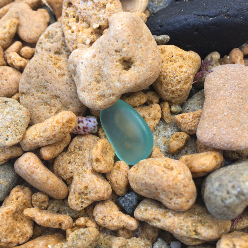 Blue sea glass in beach rock mix photographed by Mornington Sea Glass on the Mornington Peninsula, Victoria, Australia.