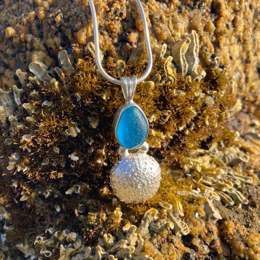 Sterling silver necklace of a cast silver sea urchin with a rare English multi colour blue sea glass treasure. Hangs on a 40 or 45cm sterling silver chain. By Mornington Sea Glass.