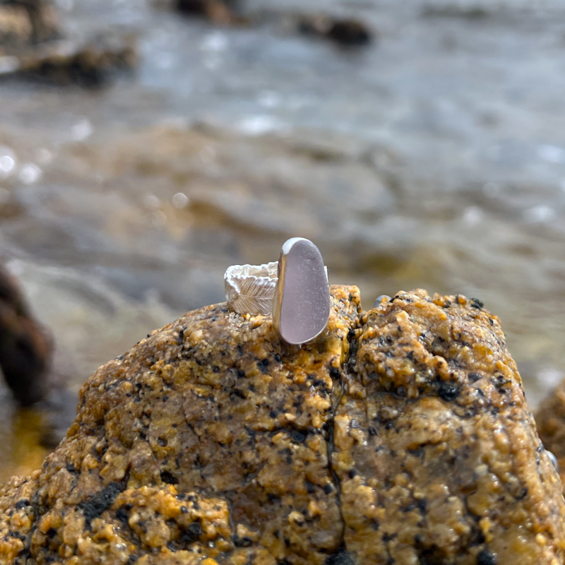 Purple sea glass set in silver on a cast beach feather inspired silver ring band by Mornington Sea Glass. Size 7 1/2.