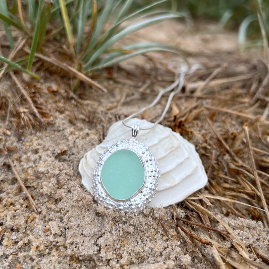Sterling silver necklace of a large 3cm cast silver sea urchin shell with seafoam sea glass from the Mornington Peninsula  set in the centre. Hangs on a 40 or 45cm sterling silver snake chain. By Mornington Sea Glass.
