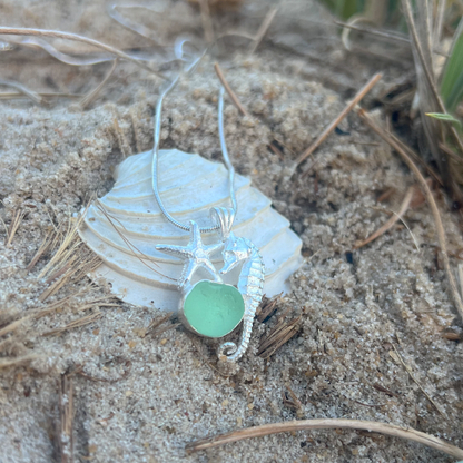 Sterling silver necklace of a small cast silver seahorse, sea star  and seafoam sea glass treasure. Hangs on a 40 or 45cm sterling silver chain. By Mornington Sea Glass.