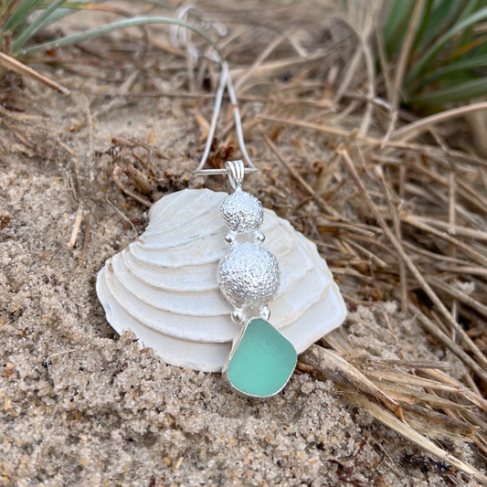 Sterling silver necklace of cast silver sea urchin shells and green sea glass. Hangs on a 40 or 45cm sterling silver chain. By Mornington Sea Glass.