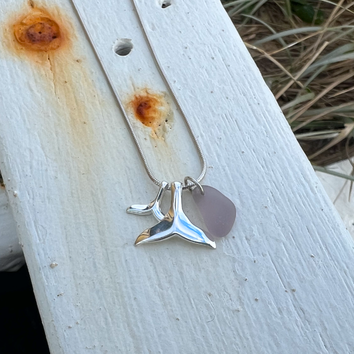 
Purple sea glass and two sterling silver whale tail charms necklace by Mornington Sea Glass. Hangs on a sterling silver 40 or 45cm snake chain.